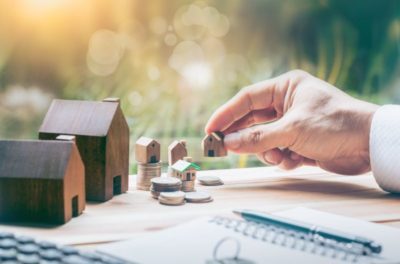 mini houses and stacks of coins