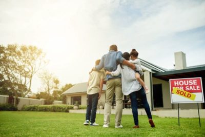 a family facing away in front of the house